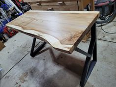 a table made out of wood and metal legs in a shop with other tools on the workbench