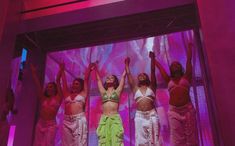 a group of women standing on top of a stage with their hands in the air