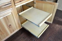 an open drawer in a kitchen with wood flooring