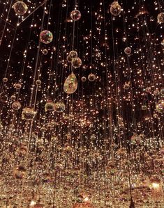 the ceiling is covered with hundreds of shiny balls hanging from it's sides and suspended by chains