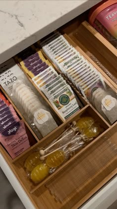 an open drawer in a kitchen filled with condiments and other food items on the counter