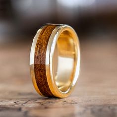 a wooden ring with gold inlays sits on a wood table, ready to be used as a wedding band