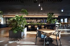 an empty restaurant with tables, chairs and potted plants