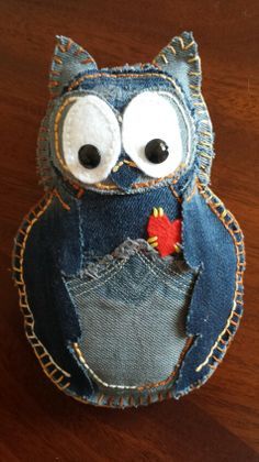 an owl made out of jeans sitting on top of a wooden table