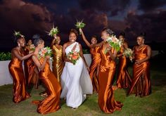 a group of women standing next to each other holding bouquets in front of them