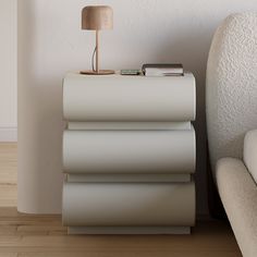 a white couch sitting next to a lamp on top of a table