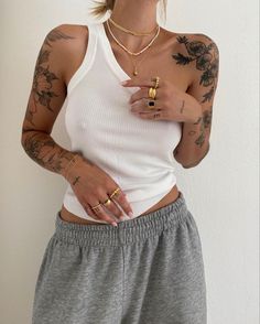 a woman with tattoos on her arms and chest holding a cell phone in her hand