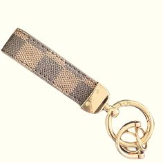 a gold key chain with a checkered pattern on it