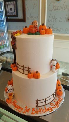 a three tiered cake decorated with pumpkins and farm animals