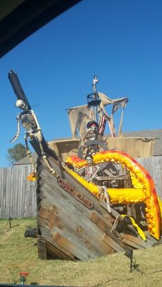 a pirate ship made out of wooden planks in the yard with skeletons on it