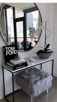 a mirror sitting on top of a table next to a vase with flowers in it