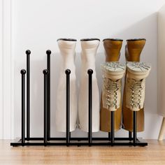 four pairs of shoes are lined up on the floor in front of a radiator