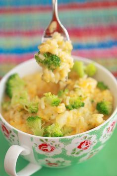 a spoon full of broccoli and rice in a bowl