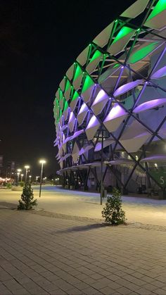 a large building lit up with green and purple lights