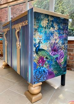 an artisticly painted cabinet with peacocks and flowers on it