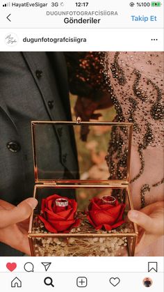 two people holding red roses in a small box with the bride's name on it