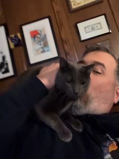 a man holding a cat up to his face