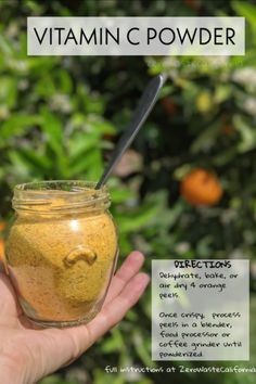 a hand holding a jar filled with yellow powder