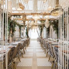 an indoor dining area with tables, chairs and chandeliers hanging from the ceiling