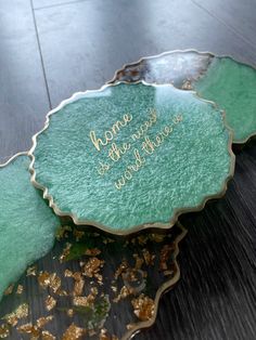 a green plate with writing on it sitting on top of a wooden table next to other plates