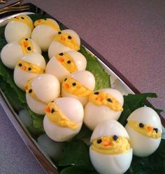 some kind of food that looks like eggs with chicks in them on top of leaves