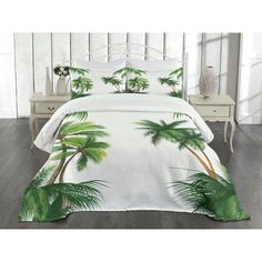 a white bed with palm trees on it