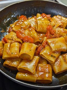 a skillet filled with pasta and tomatoes