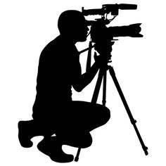 a man kneeling down with a camera in front of his face and holding a tripod