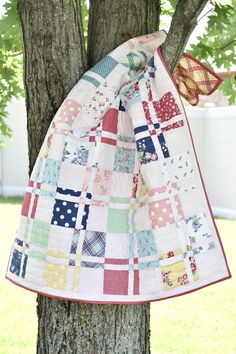 a patchwork quilt hanging from a tree