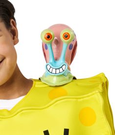 a young boy is smiling and holding up a toy monster head with his mouth open