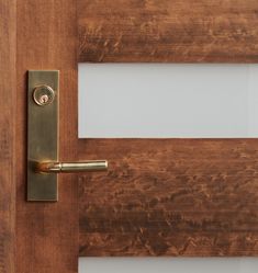 a door handle on a wooden door with white glass in the front and side panels