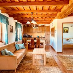 a living room filled with furniture next to a kitchen and dining room table on top of a wooden floor