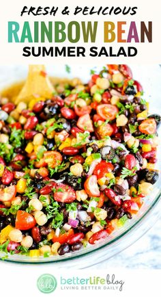 fresh and delicious rainbow bean summer salad in a glass bowl with a wooden spoon on the side