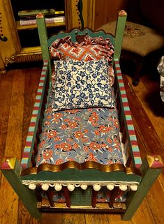 a bed made out of an old fashioned wooden frame with colorful fabric on it's sides