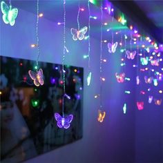 some lights that are hanging from the ceiling with butterflies on them and in front of a mirror