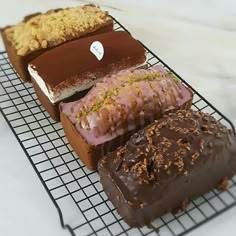 four different types of doughnuts on a cooling rack