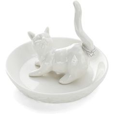 a white cat figurine sitting on top of a plate