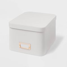 a white storage box with gold handles on the top and bottom, sitting against a white background