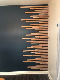 the wall is made out of wood sticks and has been painted black with white trim