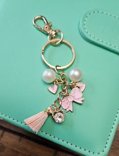 a keychain with a tassel and charms attached to it on a green purse