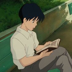 a man sitting on a bench reading a book