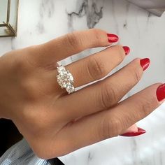 a woman's hand with red nail polish and a ring on her left hand