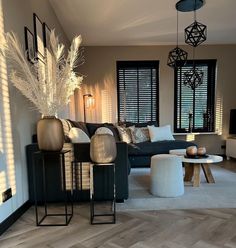 a living room filled with lots of furniture next to a window covered in shades of white