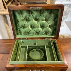 an open wooden box with green velvet inside