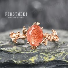 an orange ring with leaves on it sitting on top of a piece of rock in front of