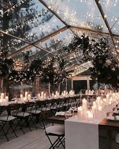 an indoor tent with tables and chairs set up for a formal dinner or wedding reception