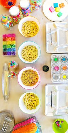 the table is full of colorful food and craft supplies