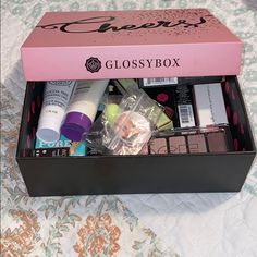 a pink box with various items inside on a bed