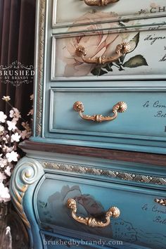 an antique dresser painted in blue and gold