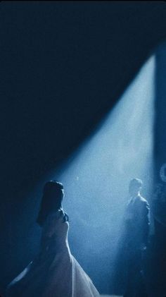 a man and woman standing in front of a stage with light coming from behind them